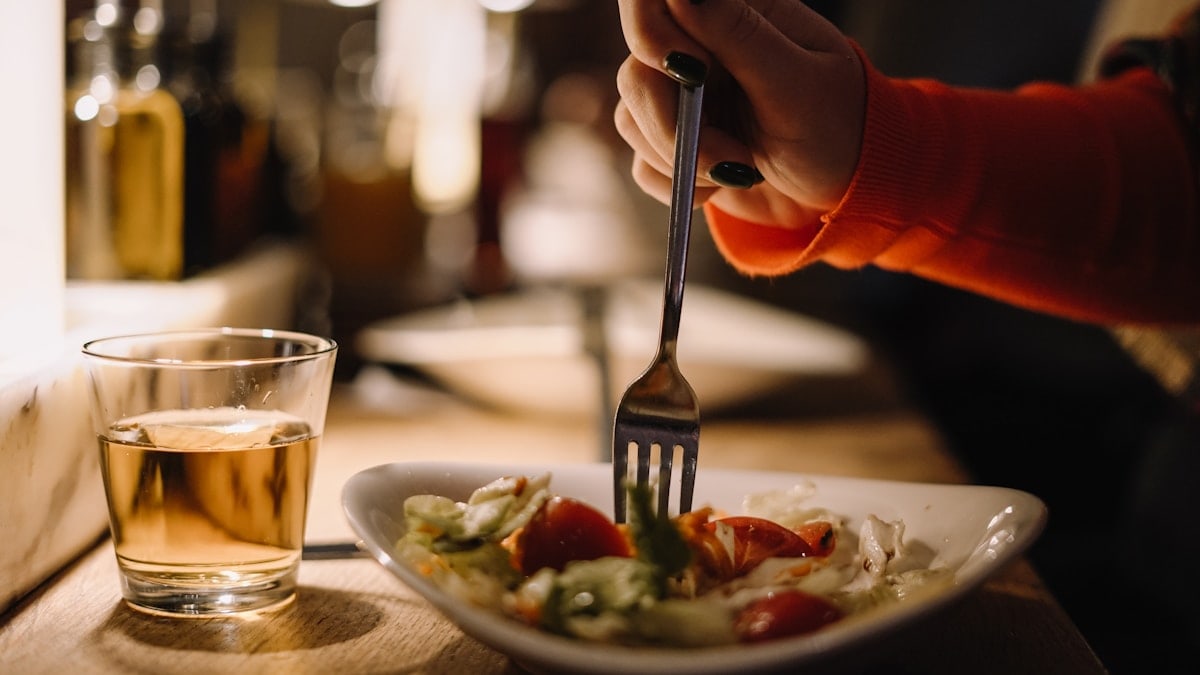 a person holding a fork over a plate of food